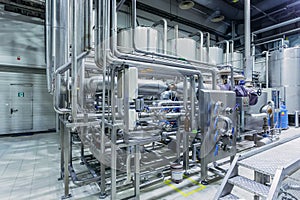 Modern brewery interior. Filtration vats, pipeline, valves and other equipment of beer production line