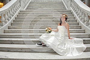 Modern bride sitting on staircase