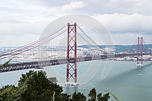 Modern bridge on April 25 in Lisbon in cloudy cloudy weather