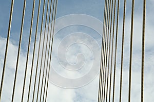 Modern bridge cables against blue sky, low angle view photo