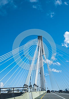 Modern bridge pylon against a blue sky. Detail of a multi-span cable-stayed bridge. White cable-stayed suspension bridge