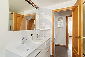 Modern bright bathroom in a house with white tiles and rectangular large mirror