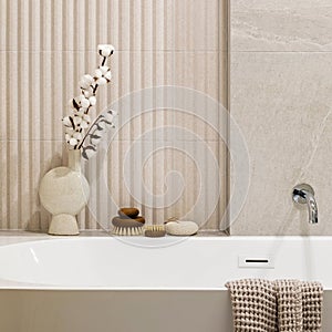 Modern bright bathroom with lamella wall. Big white bath with silver faucet, dried flowers and brown towel photo