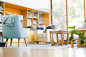Modern bright living room featuring pastel blue chair well-lit on bright spring day