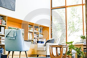 Modern bright living room featuring pastel blue chair well-lit on bright spring day