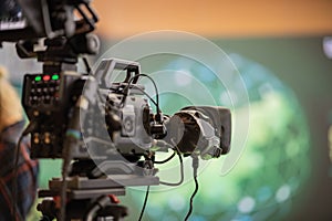 Modern broadcasting camera on a stand, ready to go live on an event. Back view of a video camera at a conference for live stream