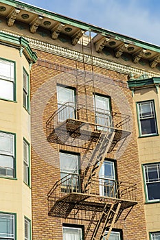 Modern brown stone facade on outside of house with black metal fire escape ladder for saftey from disasters