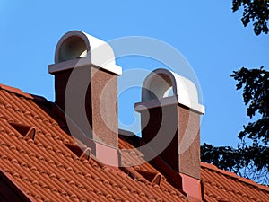 Modern brown stucco finished chimneys with white ceramic cap stones