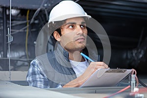 modern builder with clipboard in roof photo