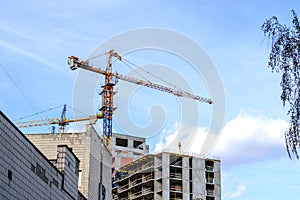 Modern building activity. Tall tower crane at a construction site when building a house