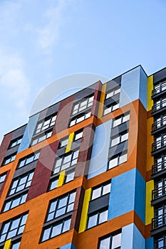 Modern building angle and windows. Multistory new multicolored apartment building. Stylish living block of flats. Bright