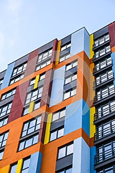 Modern building angle and windows. Multistory new multicolored apartment building. Stylish living block of flats. Bright