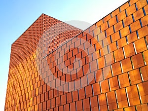 Modern building bright orange facade made of panels