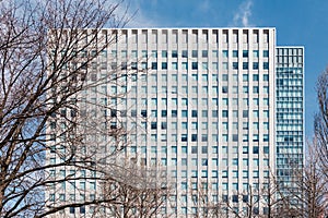 Modern building facede with rectangle and square windows form with clear blue sky and Leafless trees in the foreground in Sapporo.