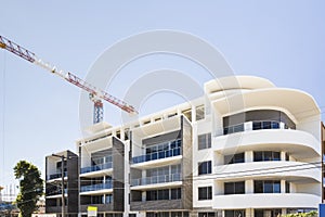 Modern building finishing with a crane under blue sky