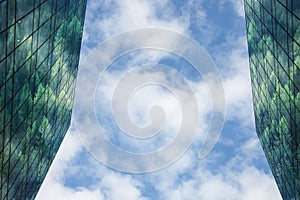 Modern building with forest reflected in windows and facade,blue sky and clouds in background. Sustainable, low