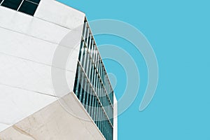 Modern building fragment against the background of the blue sky.