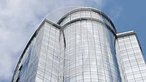 Modern building with glazed facade with sky and clouds reflection