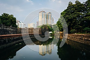 Modern building reflecting in the moat at Fort Santiago, in Intramuros, Manila, The Philippines.