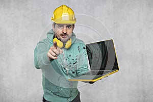 Modern building supervisor keeps the computer in his hands, technology at work