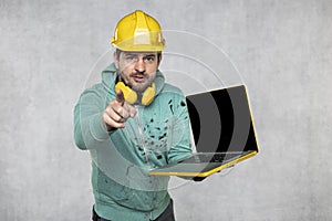 Modern building supervisor keeps the computer in his hands, technology at work