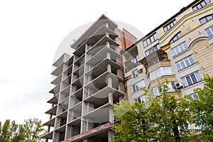 Modern building under construction against blue sky. Construction work site