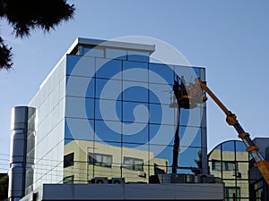 Modern Building Window Washing From Elevated Cherry Picker Lift