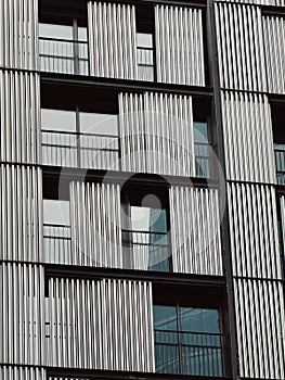 Modern building with windows and metallic lined shades in Spain. Vertical photo