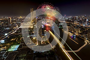 Modern buildings in the city with water reflection, firework, light show at night time