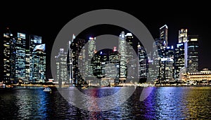 Modern buildings and lights on sea and abstract architectures and night skyline in Singapore photo