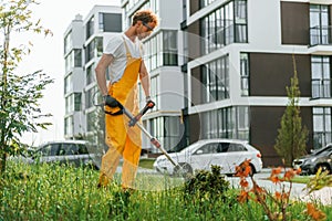 Modern buildings. Man cut the grass with lawn mover outdoors in the yard