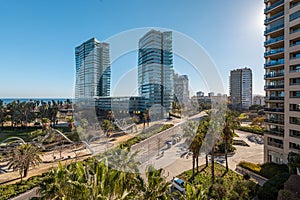Modern buildings and sunny park in coastal area with sea view, distict Diagonal mar in Barcelona, Spain