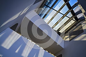 Modern buildings of unusual forms from glass and metal. Geometry of lines and curves. The inclined facade. Blue sky.