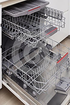 Modern built-in empty dishwasher with open door