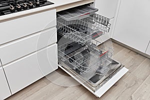 Modern built-in empty dishwasher with open door