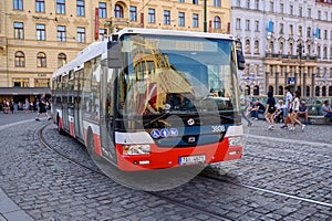 A modern bus rounds a corner on the cobbled streets of the old town district of Prague