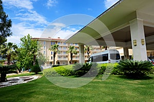 The modern bus for tourists transportation is near entrance to hotel