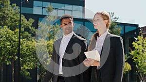 Modern business building architecture happy and excited woman and black guy office managers at the break time walking