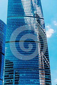 Modern business building. Clouds and buildings are reflected in the windows of the skyscraper of a commercial modern