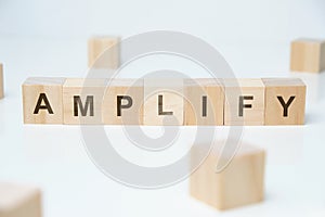 Modern business buzzword - amplify. Word on wooden blocks on a white background