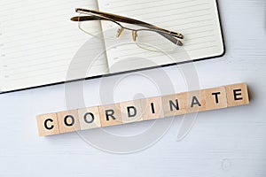 Modern business buzzword - coordinate. Top view on wooden table with blocks. Top view