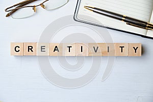 Modern business buzzword - creativity. Top view on wooden table with blocks. Top view