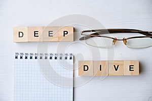 Modern business buzzword - deep dive. Top view on wooden table with blocks. Top view