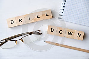 Modern business buzzword - drill down. Top view on wooden table with blocks. Top view