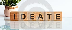 Modern business buzzword - ideate. Word on wooden blocks on a white background. Close up