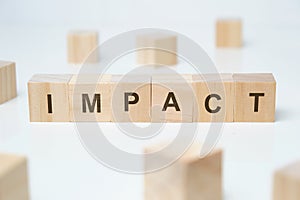 Modern business buzzword - impact. Word on wooden blocks on a white background