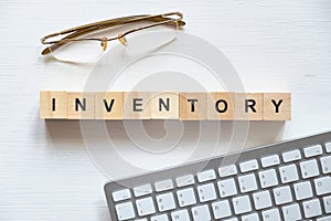 Modern business buzzword - inventory. Top view on the board keyboard glasses with wooden blocks. Top view