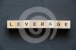 Modern business buzzword - Leverage. Top view on wooden table with blocks. Top view