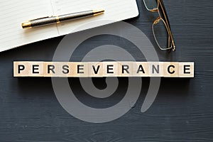 Modern business buzzword - perseverance. Top view on wooden table with blocks. Top view