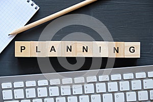 Modern business buzzword - planning. Top view on wooden table with blocks. Top view